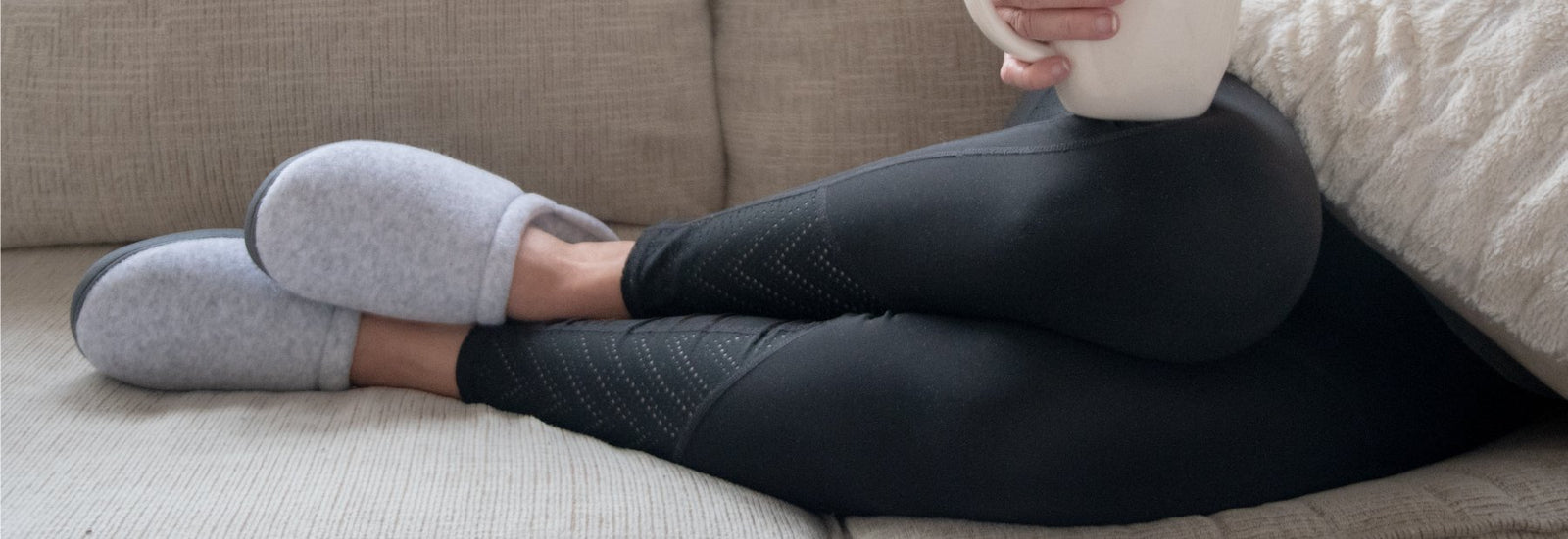 Women's Terry Clog Slippers on figure laying on couch with coffee