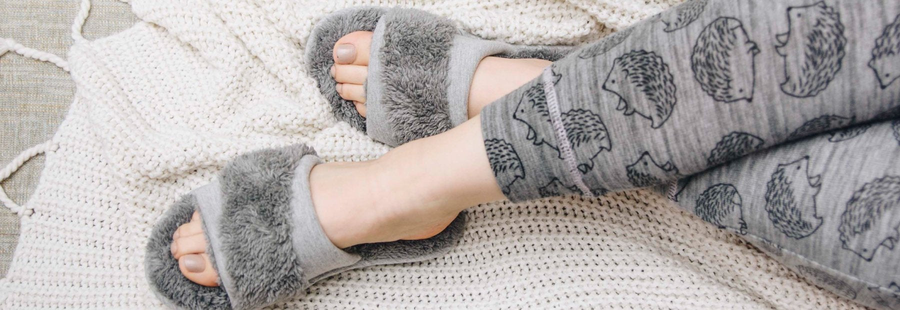 Women's Dani Waffle Knit Slide Slippers and Women’s Linley Jersey and Chenille Slide Slippers lined up in variety of colors flat lay on purple backdrop