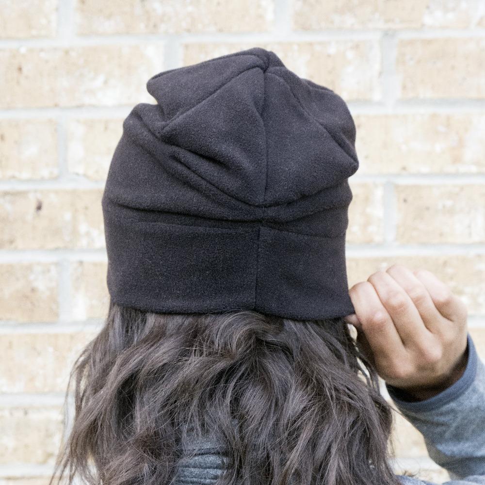 Women's Lined Recycled Fleece Beanie with Rushed Back in Black on figure. Model wearing hat, pulling the back down