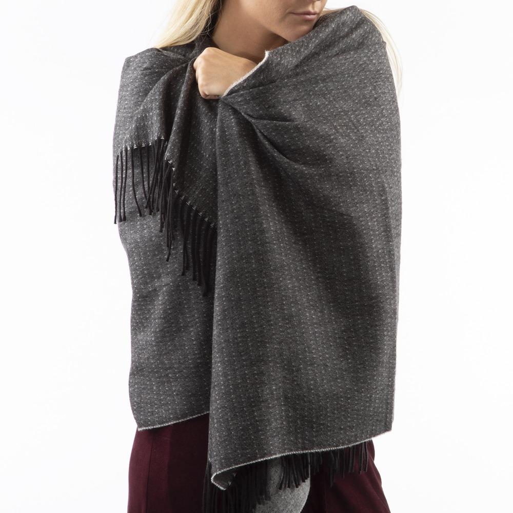 Women’s Recycled Scarf with Fringe in Black on model. Scarf wrapped around her shoulders like a blanket Front View.