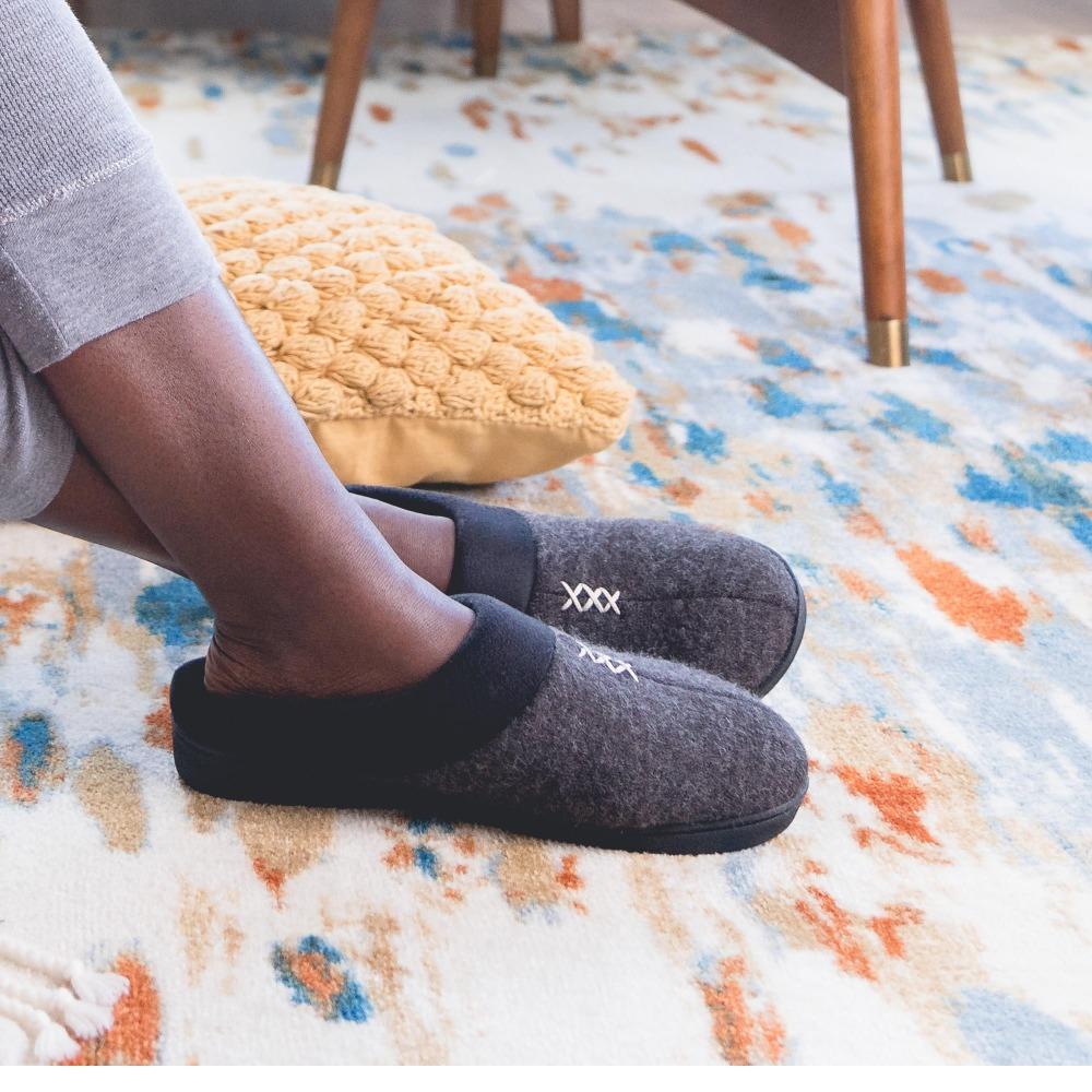 Women's Marisol Microsuede Knit Hoodback Slippers in Black on model on a printed rug