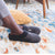 Women's Marisol Microsuede Knit Hoodback Slippers in Black on model on a printed rug