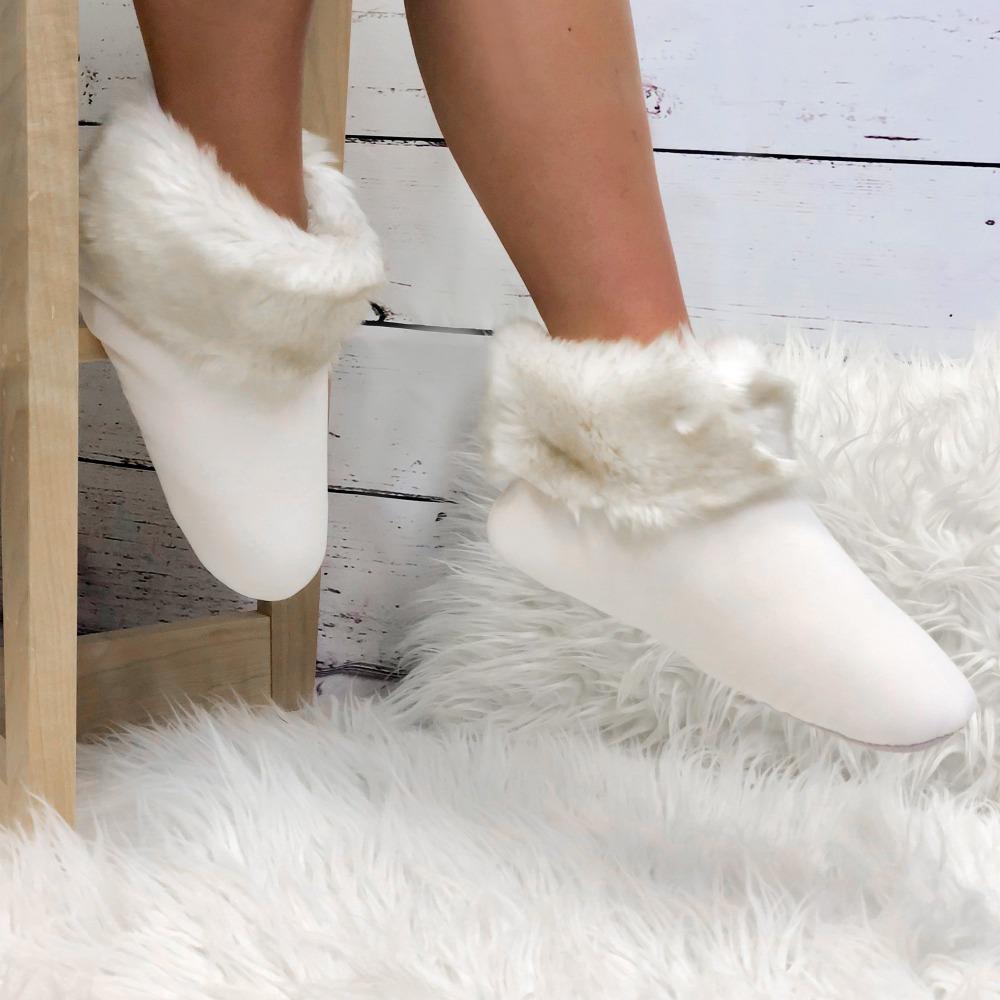 Women's Stretch Velour Sabrine Bootie Slippers in Ewe on Model sitting on stool around a fur rug
