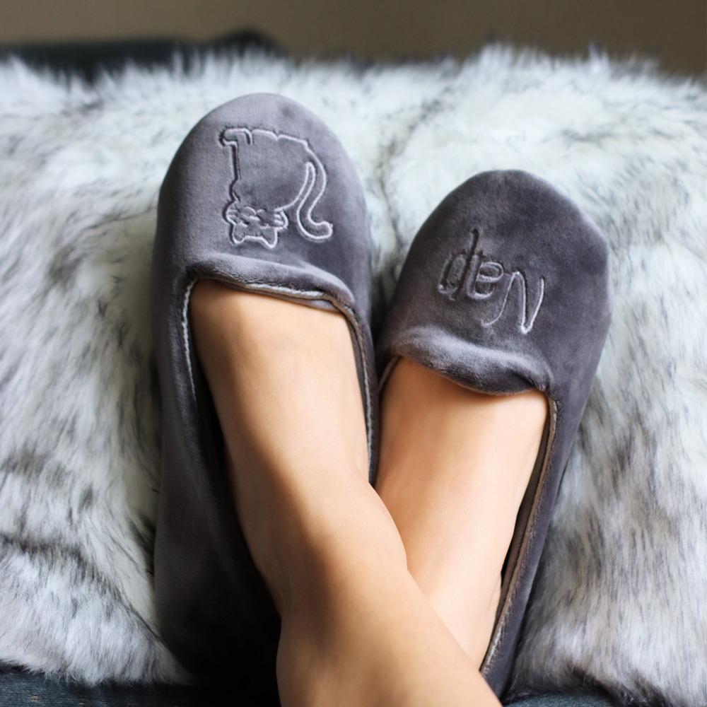 Women's Velour Conversational Smoking Slippers Pair in Mineral one slipper has an illustration of a Cat, the other says "Nap" on Model with her feet up