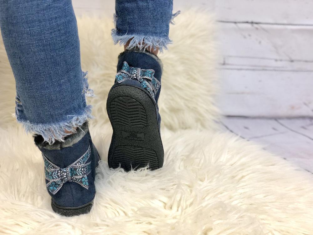 Women's Microsuede Nora Bootie Slippers in Navy Blue on Model standing on fur rug
