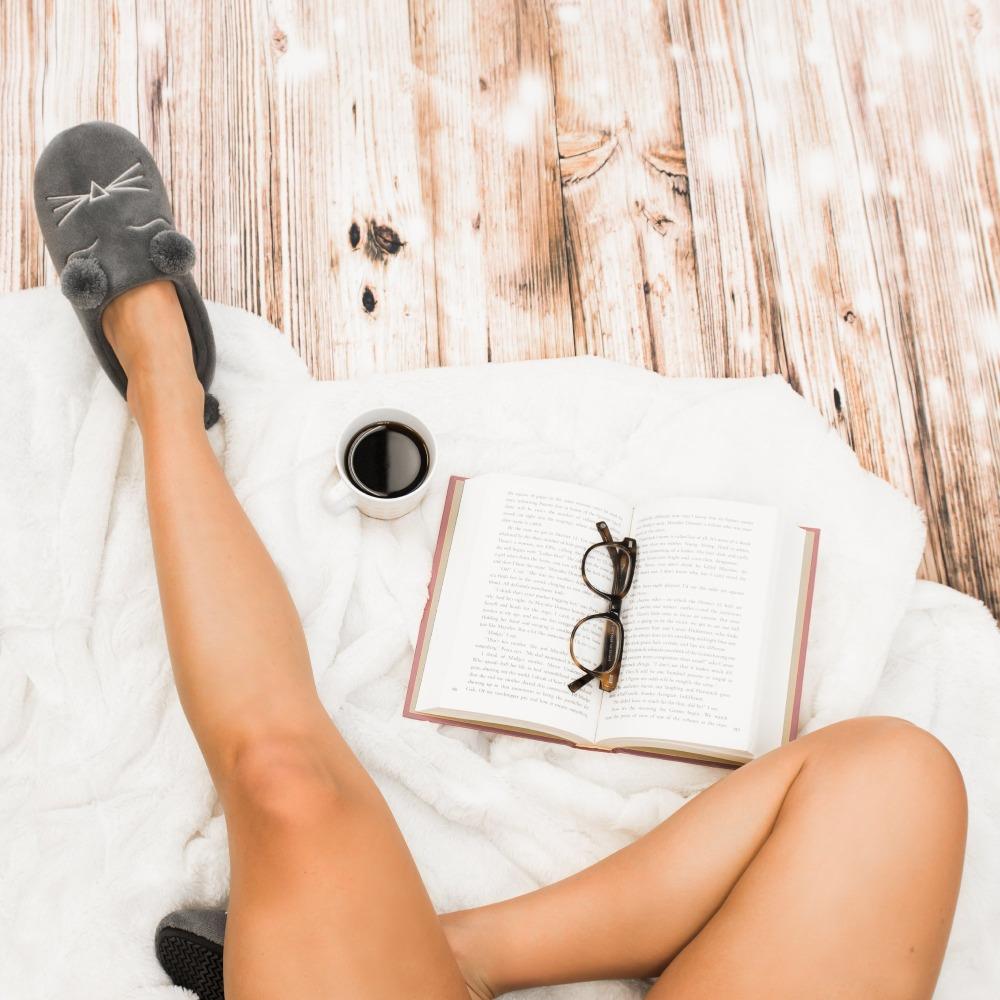 Women's Microterry Critter Hoodback Slippers in Ash on model with blankets, coffee and a book