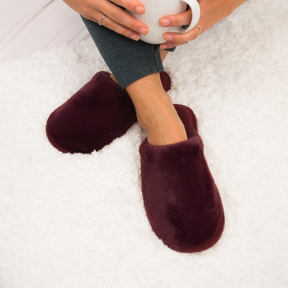 Women's Faux Fur Laurel Clog Slippers in Henna (Maroon) on Model on Fur Rug with Coffee Mug