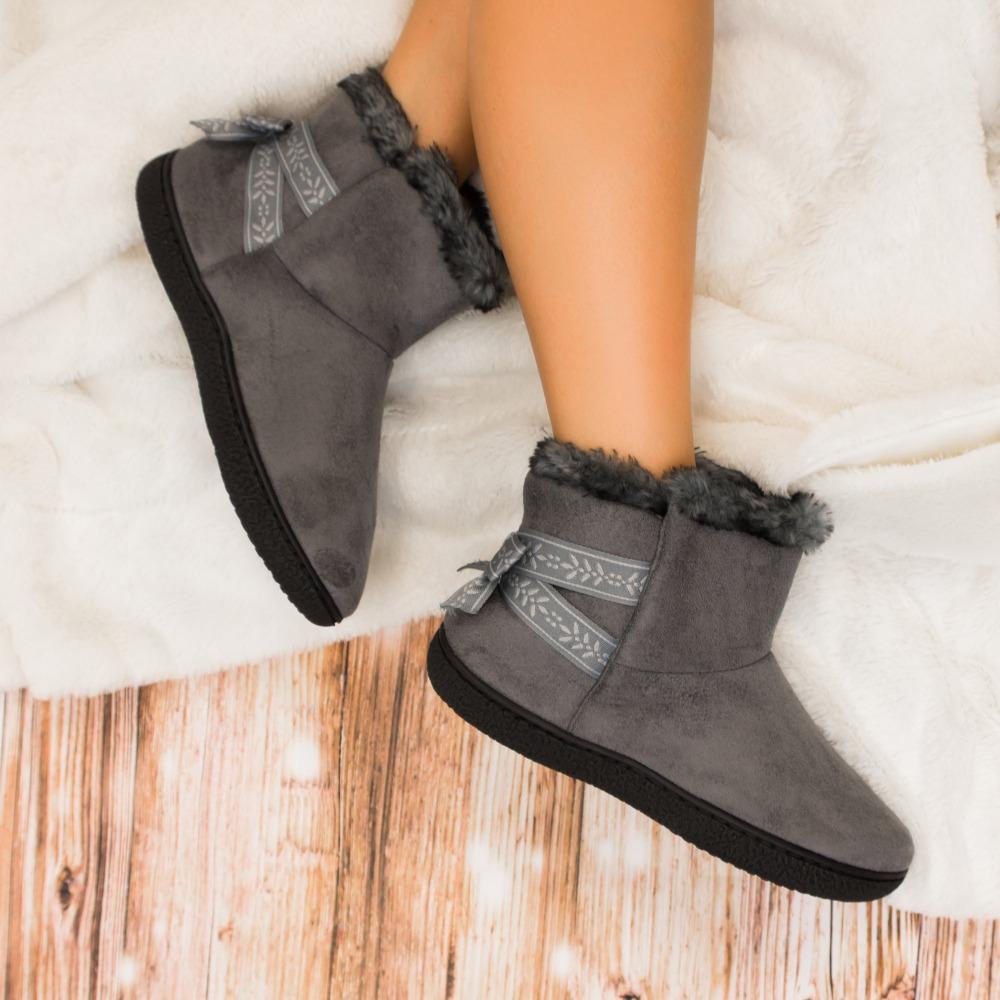 Women's Microsuede Addie Boot Slippers with Bow in Ash On Model laying on plush blanket on hardwood floor