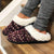 Women's Sweater Knit Amanda Hoodback Slippers in Henna (Maroon) on Model sitting on the stairs